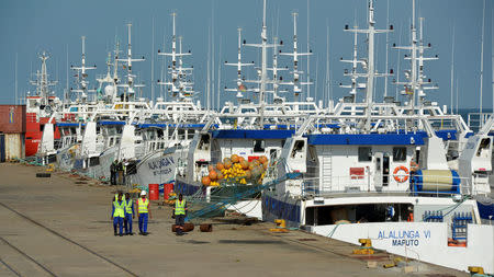 FILE PHOTO: Security guards patrol past a fishing fleet docked in Maputo, Mozambique, May 3, 2016. REUTERS/Grant Lee Neuenburg/File Photo