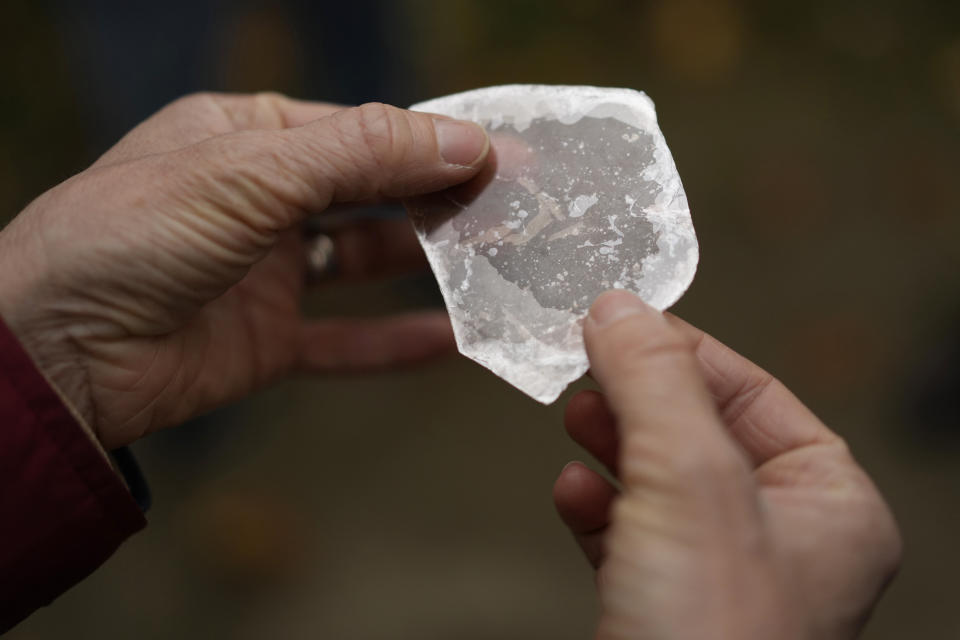 A piece of mica rock, an example of what could be found at the Mound City Group, is passed around a tour group at the Mound City Group at Hopewell Culture National Historical Park in Chillicothe, Ohio, Saturday, Oct. 14, 2023. A network of ancient American Indian ceremonial and burial mounds in Ohio noted for their good condition, distinct style and cultural significance, including Hopewell, was added to the list of UNESCO World Heritage sites. (AP Photo/Carolyn Kaster)