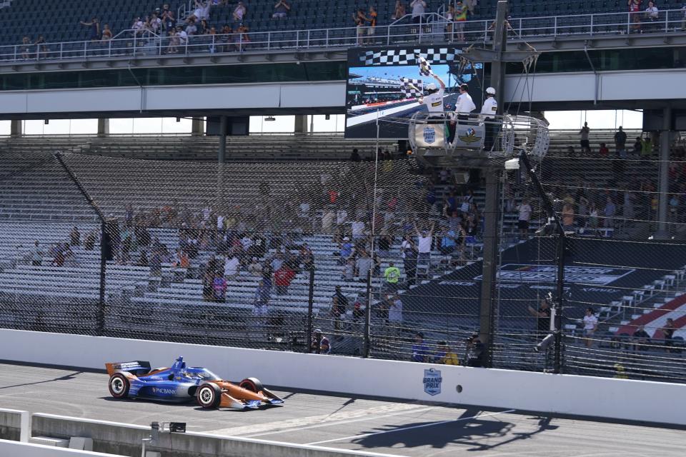 Scott Dixon, of New Zealand, takes the checkered flag to win an IndyCar Indianapolis GP auto race at Indianapolis Motor Speedway, Saturday, Aug. 12, 2023, in Indianapolis. (AP Photo/Darron Cummings)