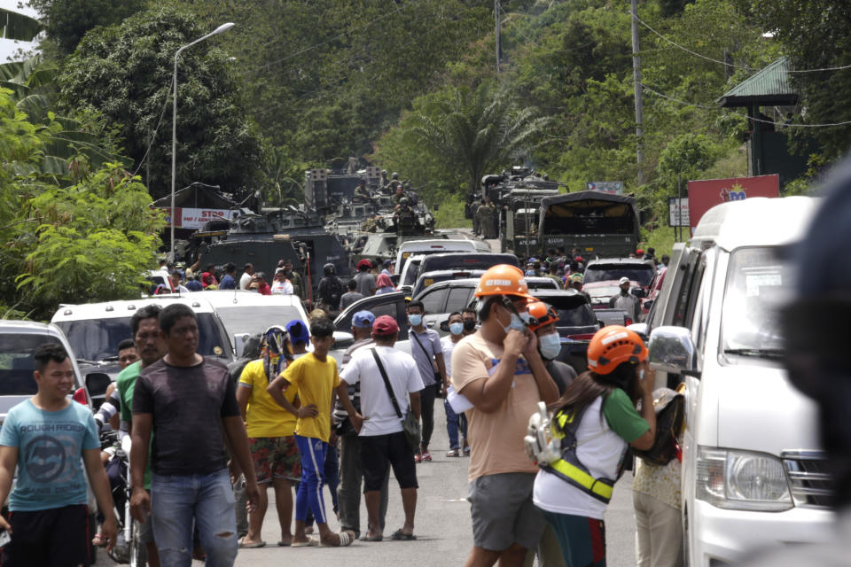 Residents wait at a checkpoint in Datu Paglas, Maguindanao province, southern Philippines on Saturday May 8, 2021. Dozens of Muslim militants occupied a public market overnight in the southern Philippines before fleeing after a tense standoff with government forces, officials said Saturday. (AP Photo/Ferdinandh Cabrera)