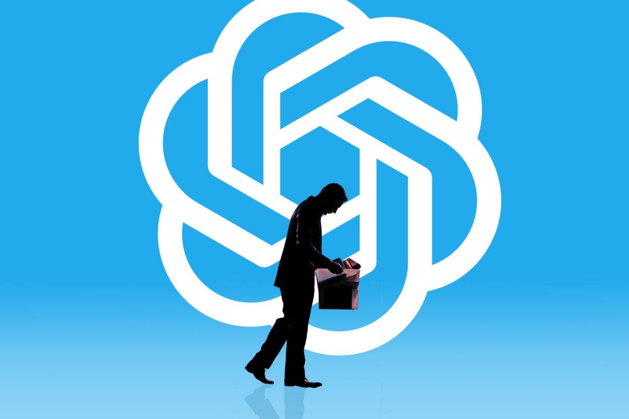 A just-laid-off worker sadly carries a box of his stuff out of his office. Behind him is a blue background with the ChatGPT logo.