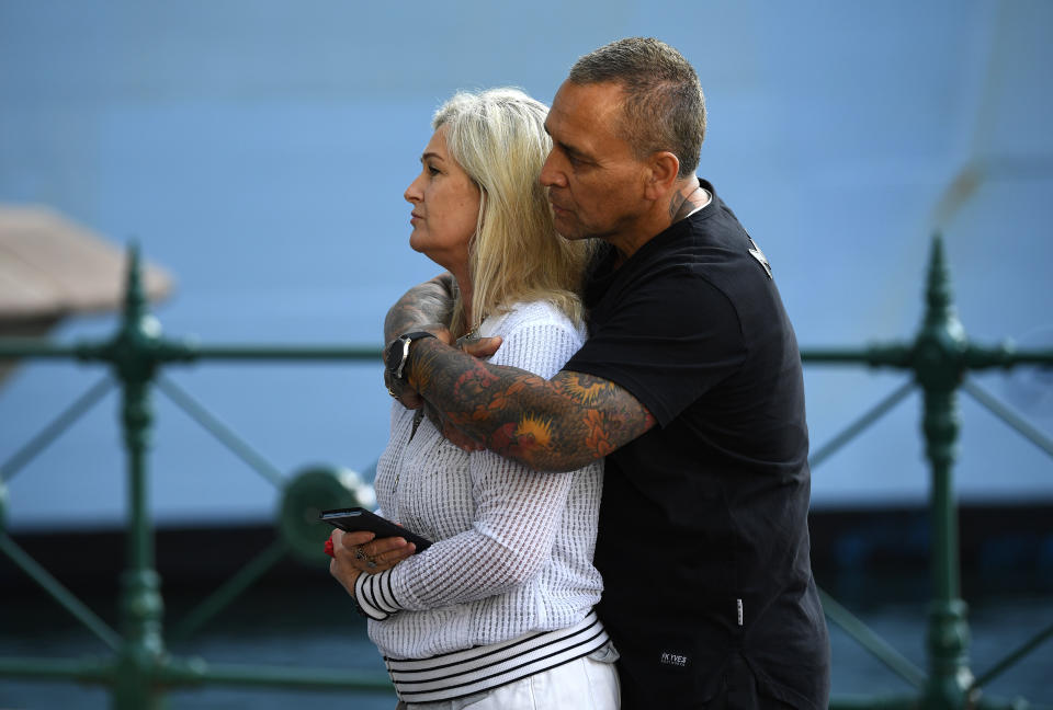 A couple wait for passengers disembarking the Royal Caribbean International's cruise ship Ovation of the Seas after it arrived in Sydney Harbour after returning from New Zealand.