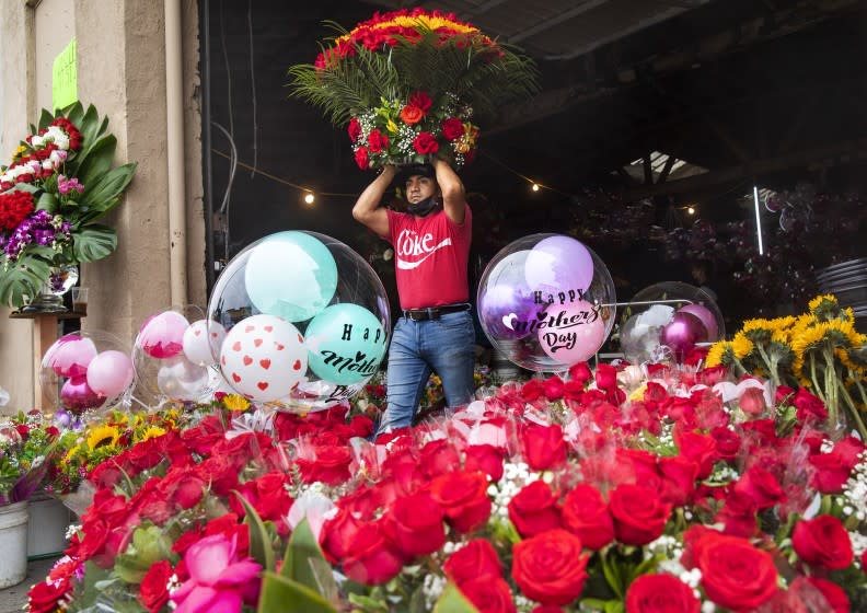 LOS ANGELES, CA - MAY 07, 2021: Fredi Santos, and employee at Pariso Floral flower shop on 8th St. in downtown Los Angeles, makes his way with with a floral arrangement for sale. Florists warn of flower shortage ahead of Mother's Day. (Mel Melcon / Los Angeles Times)