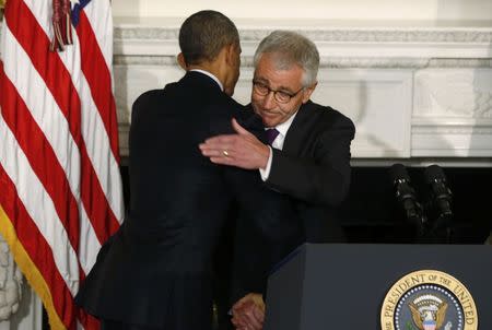 U.S. President Barack Obama (L) embraces Defense Secretary Chuck Hagel after announcing Hagel's resignation at the White House in Washington, November 24, 2014. REUTERS/Larry Downing