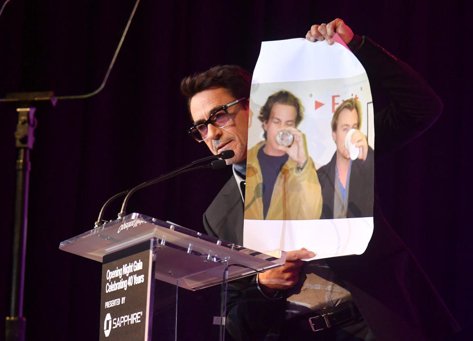 Robert Downey Jr. at Sundance’s Opening Night Gala holds up a photo of Christopher and Jonathan Nolan at the “Memento” premiere at Sundance taken in 2001.<cite>Stephen Lovekin/Shutterstock for</cite>