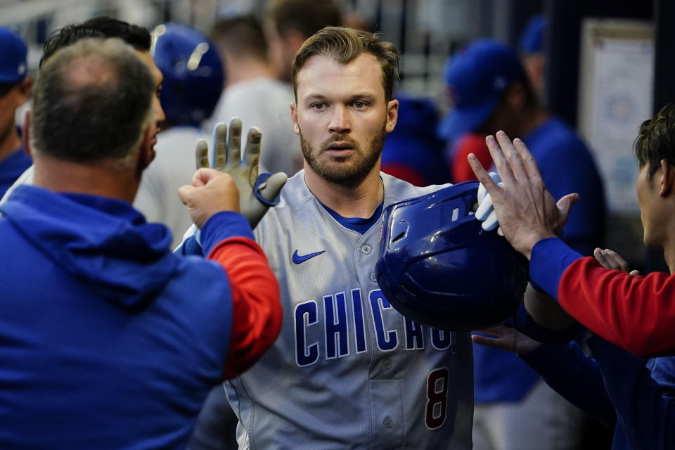 Chicago Cubs' Ian Happ (8) is greeting in the dugout after hitting a home run in the third inning of a baseball game against the Atlanta Braves, Tuesday, April 26, 2022, in Atlanta. (AP Photo/Brynn Anderson)