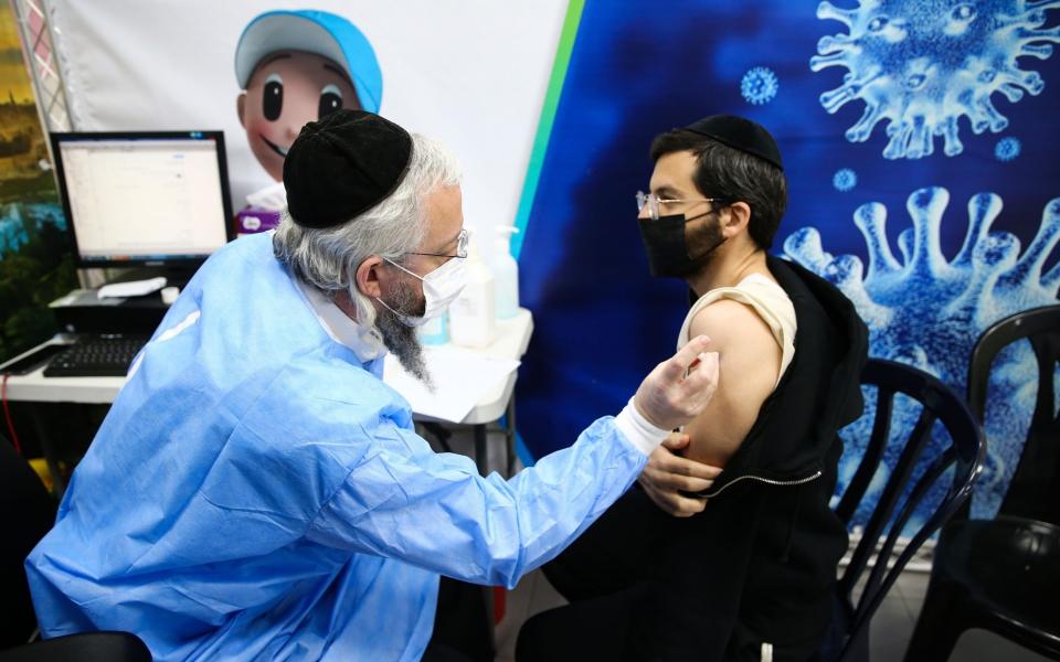 An Ultra-Orthodox Jewish receives a dose of the Pfizer vaccine, in the Israeli city of Bnei Brak -  Anadolu