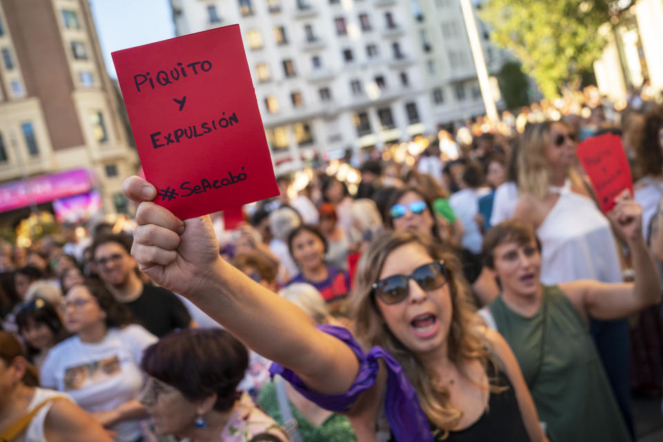 Una manifestante, con una tarjeta roja en la que dice "Piquito y dimisión", participa en una protesta contra el presidente de la Federación Española de Fútbol, Luis Rubiales, y en apoyo de la futbolista de la selección femenina Jenni Hermoso, en Madrid, el 28 de agosto de 2023. España examina el sexismo en el fútbol luego de que el jefe de la RFEF propinó un beso no consentido a una jugadora en la Copa del Mundo. (AP Foto/Andrea Comas)