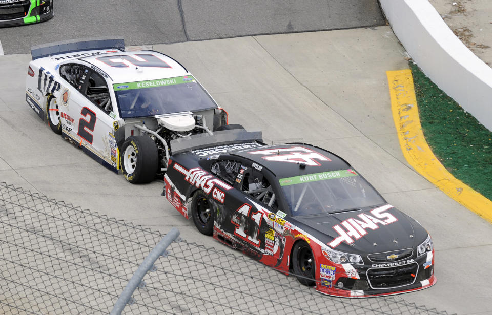 Brad Keselowski (2) bumps Kurt Busch (41) as they enter Turn 1 during a NASCAR Sprint Cup auto race at Martinsville, Speedway, Sunday, March 30, 2014, in Martinsville, Va. The two drivers were involved in a pit road accident earlier in the race. (AP Photo/Mike McCarn)