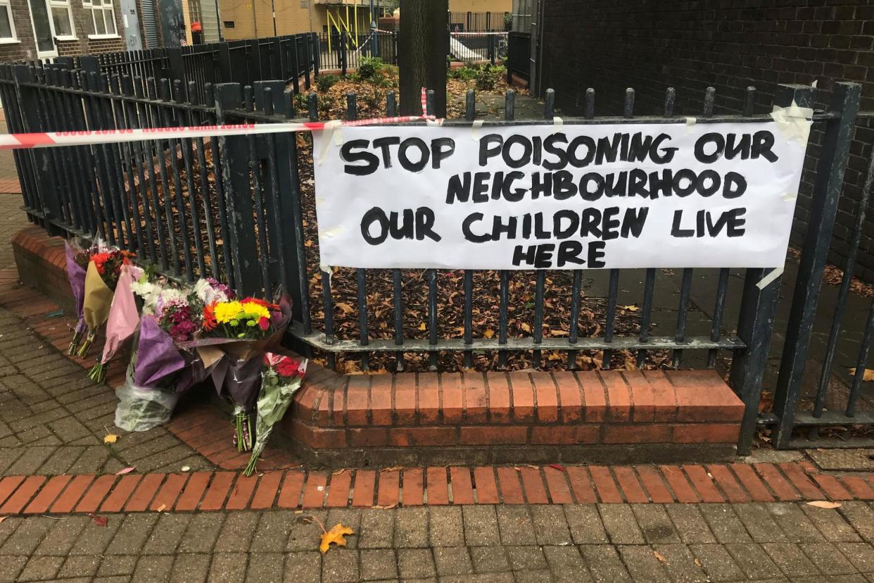 Floral tributes and a sign near where Ian Tomlin was killed: PA