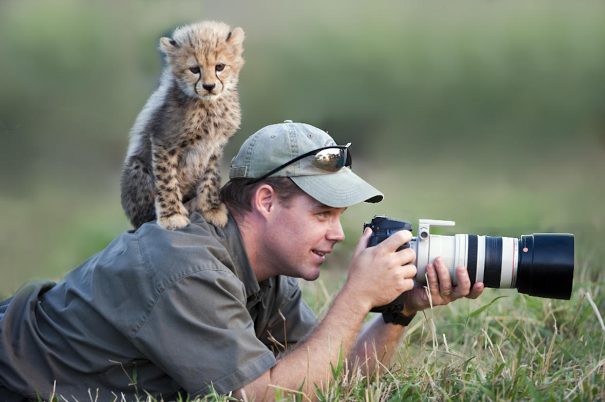 Stu Porter aims his camera, undeterred by a cub. (Photo: Stu Porter/Caters News)
