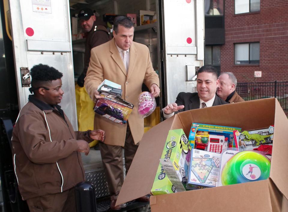 Brockton Mayor Robert Sullivan unloads toys from a UPS truck at City Hall as part of his annual toy drive which this year is dedicated to the Maryann Smith Dodge of Brockton, who passed away due to cancer in 2020. On the mayor's right is UPS driver Zachery Cole of Brockton, and to his left is John Messia, Brockton Director of Constituent Services, on Monday, Dec. 19, 2022.