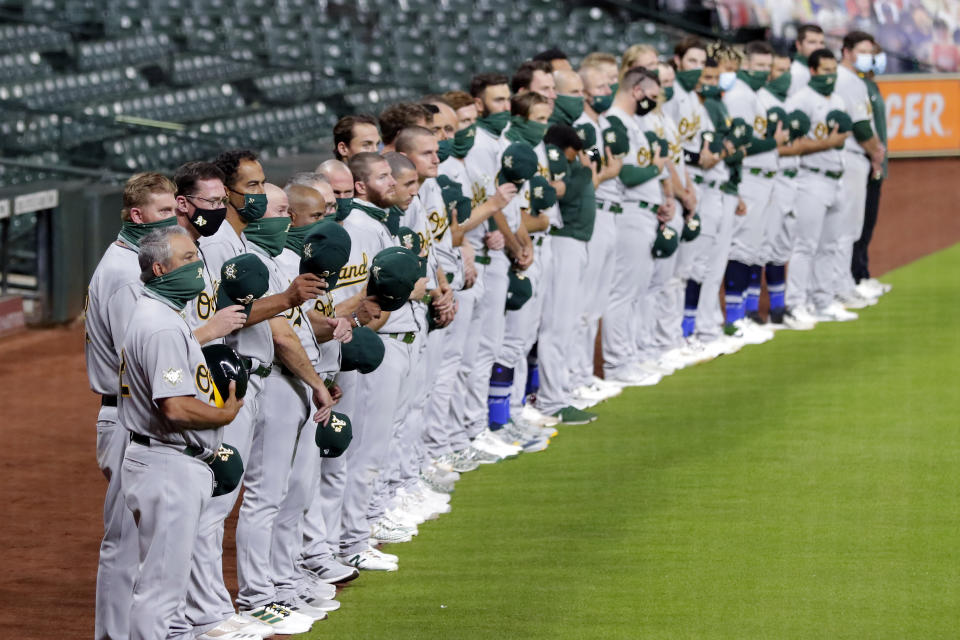 Los Atléticos de Oakland terminan de escuchar el himno nacional, antes de marcharse junto con los Astros de Houston, sin disputar el juego del viernes 28 de agosto de 2020, en protesta contra la injusticia racial (AP Foto/Michael Wyke)