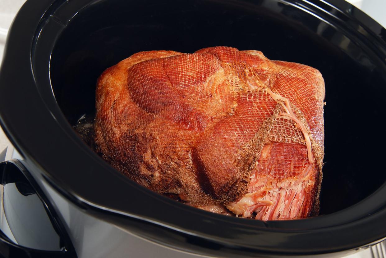 Big piece of ham cooking slowly in a crock pot
