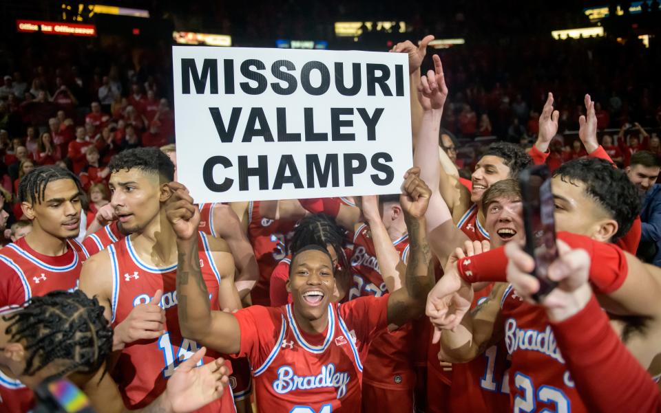 Bradley's Duke Deen, middle, holds a sign proclaiming the Braves' Missouri Valley Conference championship as he and his teammates celebrate their 73-61 victory over Drake in the regular-season finale Sunday, Feb. 26, 2023 at Carver Arena.