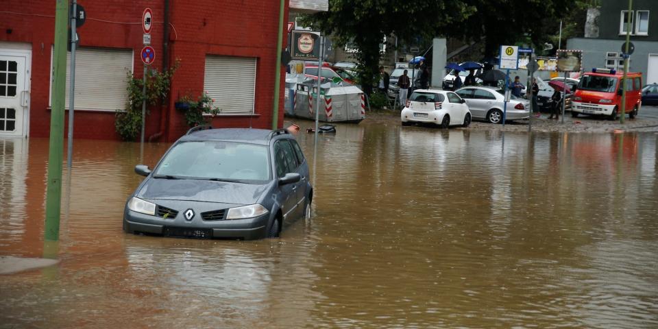 A car is seen in a flooded street following heavy rainfalls in Hagen, Germany, July 14, 2021