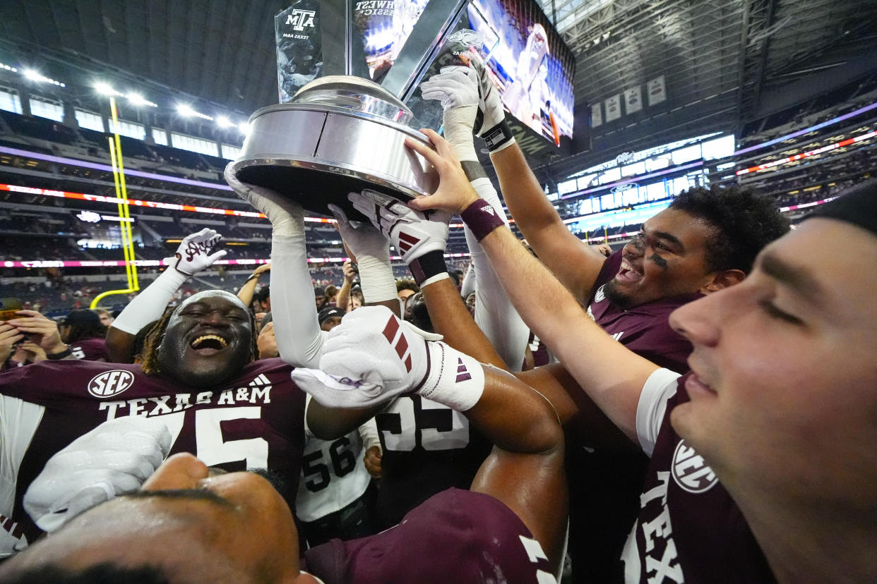 Texas A&M hold the Southwest Classic trophy after an NCAA college football game against Arkansas, Saturday, Sept. 28, 2024, in Arlington, Texas. Texas A&M won 21-17. (AP Photo/Julio Cortez)