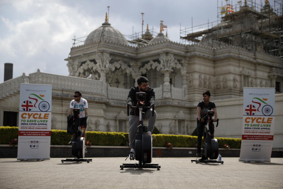 FILE - In this May 1, 2021, file photo, people take part in "Cycle to Save Lives" a 48 hour, non-stop static relay cycle challenge at the BAPS Shri Swaminarayan Mandir, also know as the Neasden Temple, the largest Hindu temple in the UK, in north London, to raise money to help coronavirus relief efforts in India. India's large diaspora — long a boon to India's economy — is tapping its wealth, political clout and expertise to help its home country combat the catastrophic coronavirus surge that has left people to die outside overwhelmed hospitals. (AP Photo/Matt Dunham, File)