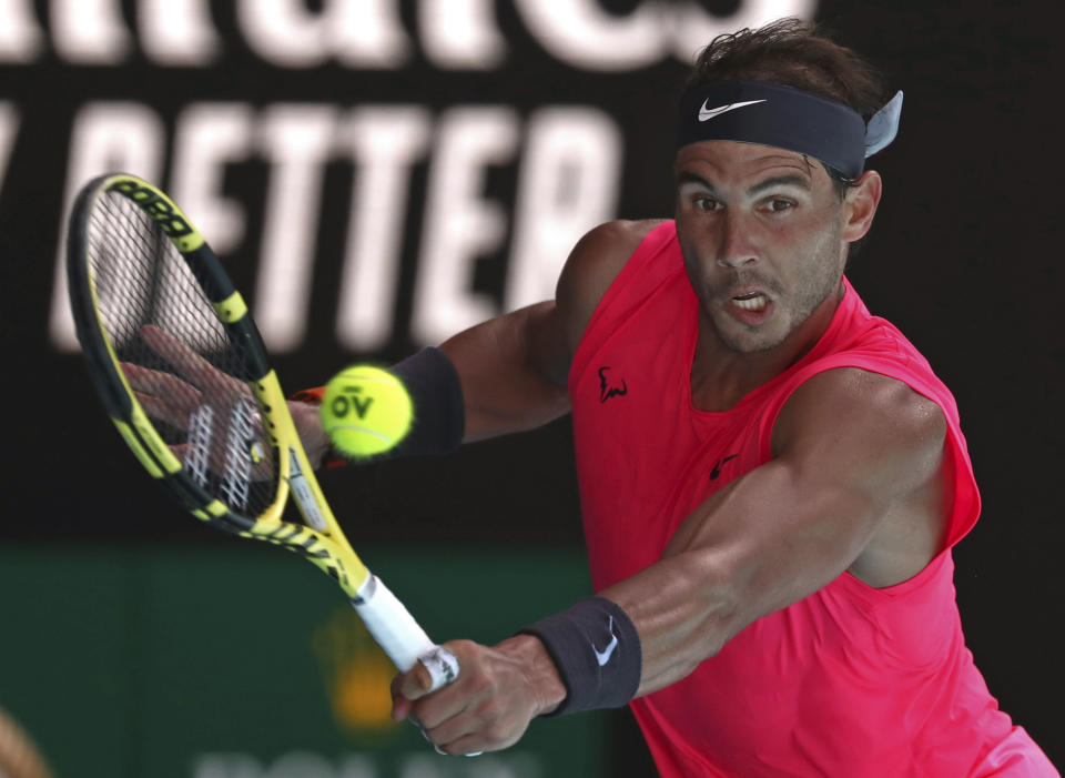 Spain's Rafael Nadal makes a backhand return to compatriot Pablo Carreno Busta during their third round singles match at the Australian Open tennis championship in Melbourne, Australia, Saturday, Jan. 25, 2020. (AP Photo/Dita Alangkara)