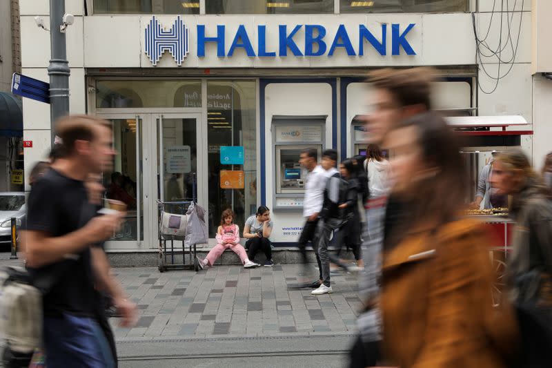 FILE PHOTO: People walk past by a branch of Halkbank in Istanbul