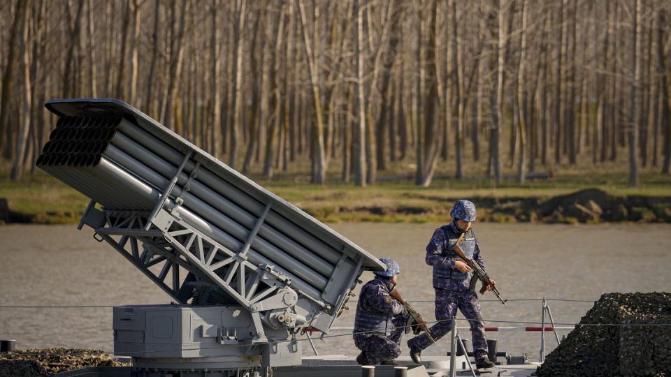 Servicemen walk on the deck of a warship sailing on the river Danube during a Romanian Navy led exercise outside Mahmudia, Romania, Thursday, March 30, 2023. (Andreea Alexandru/AP)