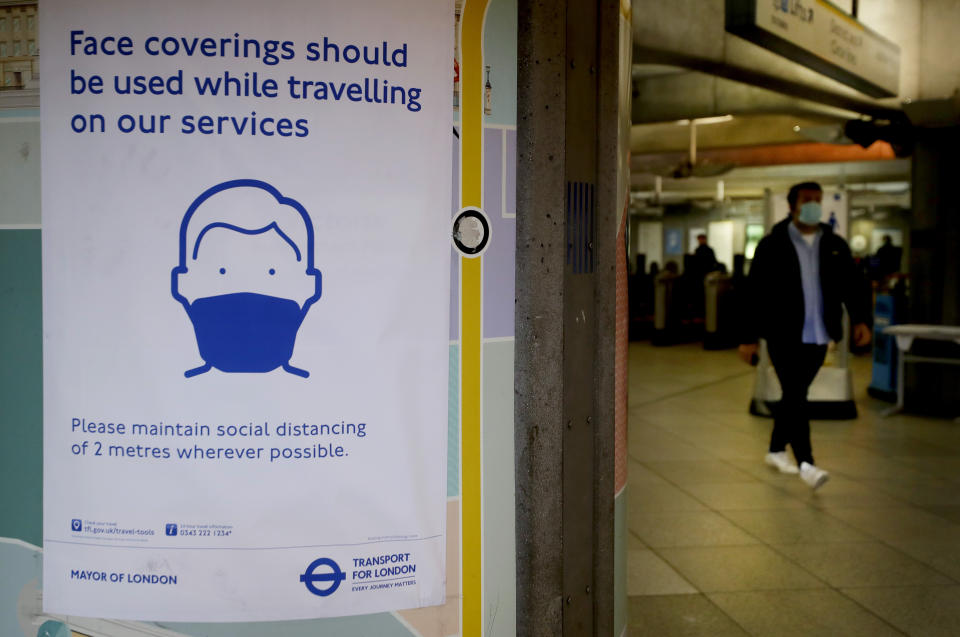 A sign advises travellers to wear face coverings at Westminster Station in London, Friday, June 5, 2020.  It will become compulsory to wear face coverings whilst using public transport in England from Monday June 15. (AP Photo/Kirsty Wigglesworth)