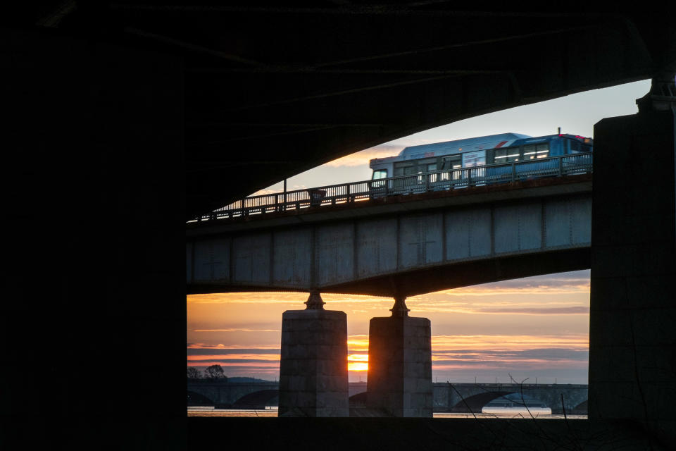 In this photograph made Tuesday, Dec. 31, 2013 a Washington Metro bus rolls across the Roosevelt Bridge over the Potomac River in Washington. Americans are riding on buses, trains and subways in greater numbers according to a report released by the American Public Transportation Association. (AP Photo/J. David Ake)