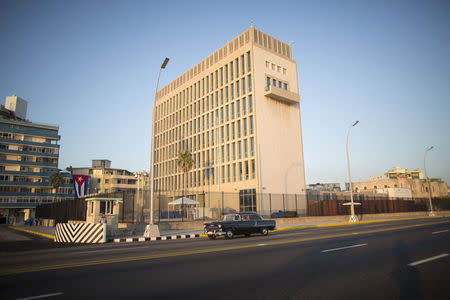 A vintage car passes by as a security officer stands on the corner of the U.S. embassy in Havana August 12, 2015. REUTERS/Alexandre Meneghini