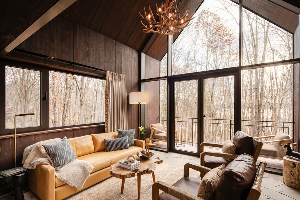 Inside a treehouse living room with a view of the landscape.