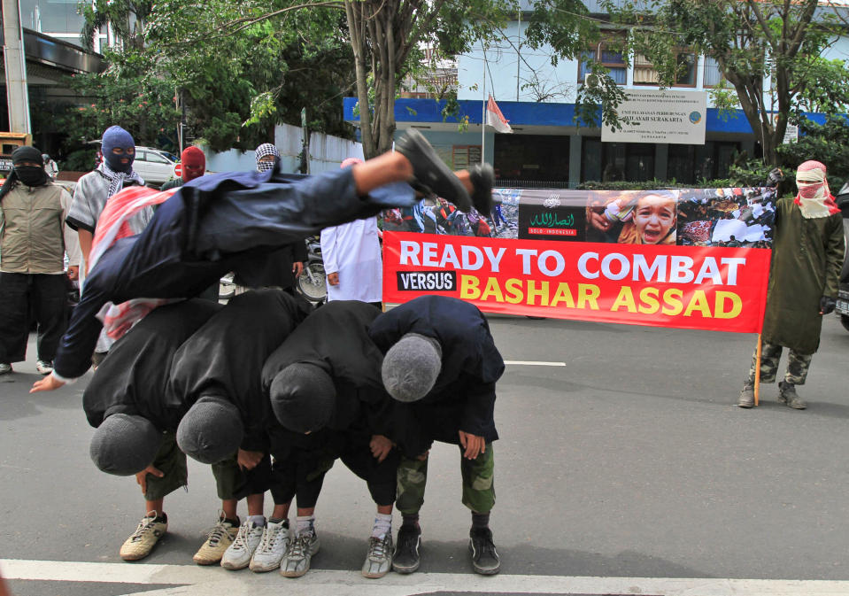 In this Sunday, June 9, 2013 photo, militants, who claimed that they are ready depart to fight the war in Syria, perform martial art techniques during a show of force in Solo, Central Java, Indonesia. While security agencies in Europe and beyond are worried about militants returning from Syria, Indonesia knows only too well how foreign battlefields, training opportunities and contact with al-Qaida can lead to deadly results. Indonesian anti-terror officials estimated there were around 50 Indonesian militants fighting against the regime of Bashar Assad in Syria and the number is expected to grow. (AP Photo)