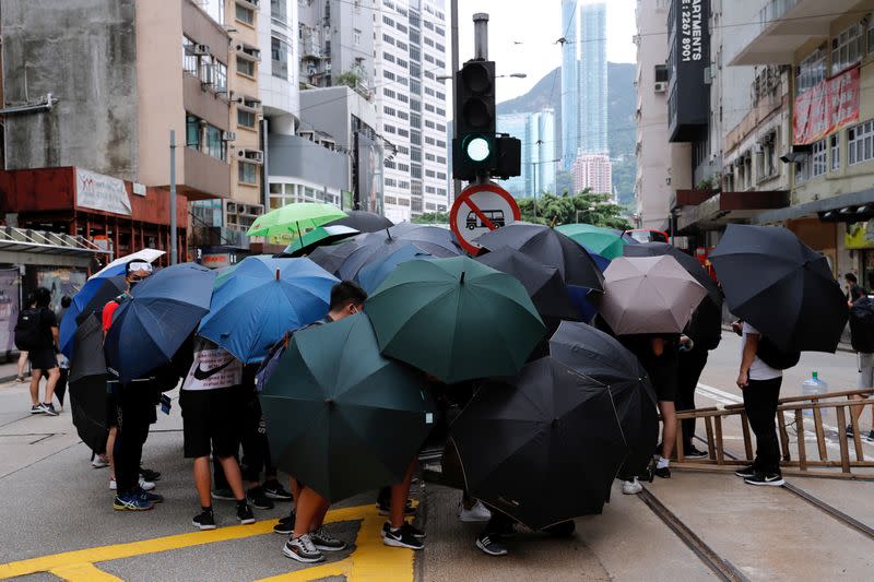 Anti-government protesters set up roadblocks under umbrellas during a march against Beijing's plans to impose national security legislation in Hong Kong