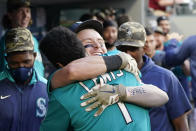 Seattle Mariners' Jarred Kelenic, center right, is embraced by Kyle Lewis (1) after hitting a two-run home run against the Cleveland Indians in the third inning of a baseball game Friday, May 14, 2021, in Seattle. (AP Photo/Elaine Thompson)