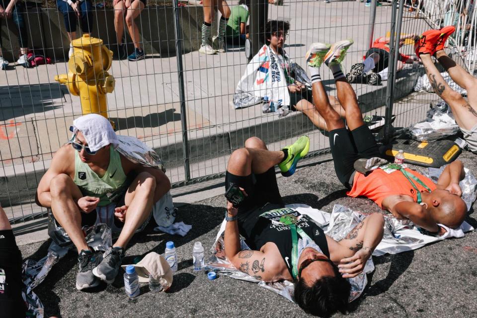 Runners rest after crossing the finish line.