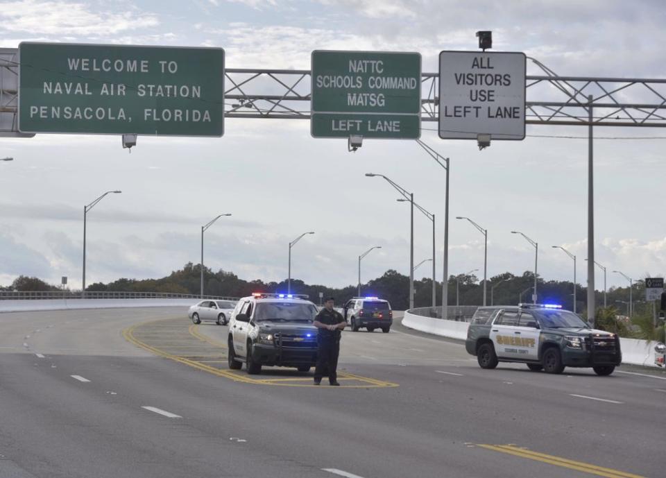 Police vehicles block the entrance to the Pensacola Air Base
