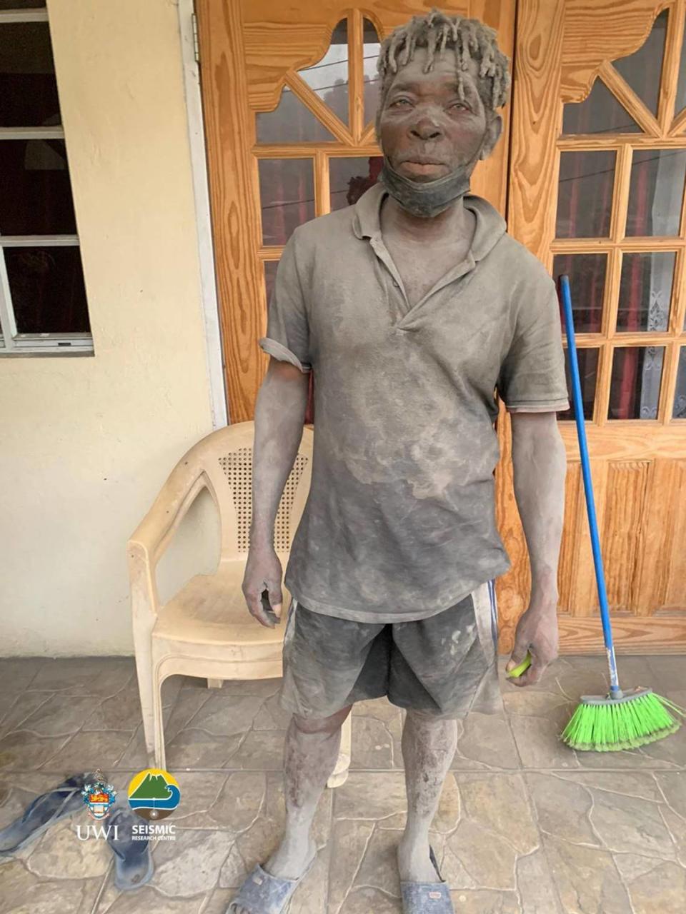 This April 10, 2021, handout image courtesy of the UWI Seismic Research Centre shows a volunteer covered in ash after the April 9 eruption of the La Soufriere Volcano, in Chateaubelair, Saint Vincent. - La Soufriere erupted for the first time in 40 years on the Caribbean island of Saint Vincent, prompting thousands of people to evacuate, seismologists said. The blast from the volcano, sent plumes of ash 20,000 feet (6,000 meters) into the air, the local emergency management agency said. The eruption was confirmed by the UWI center.