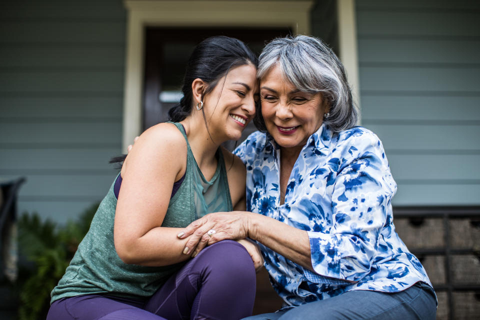 A woman and her mother are laughing and hugging