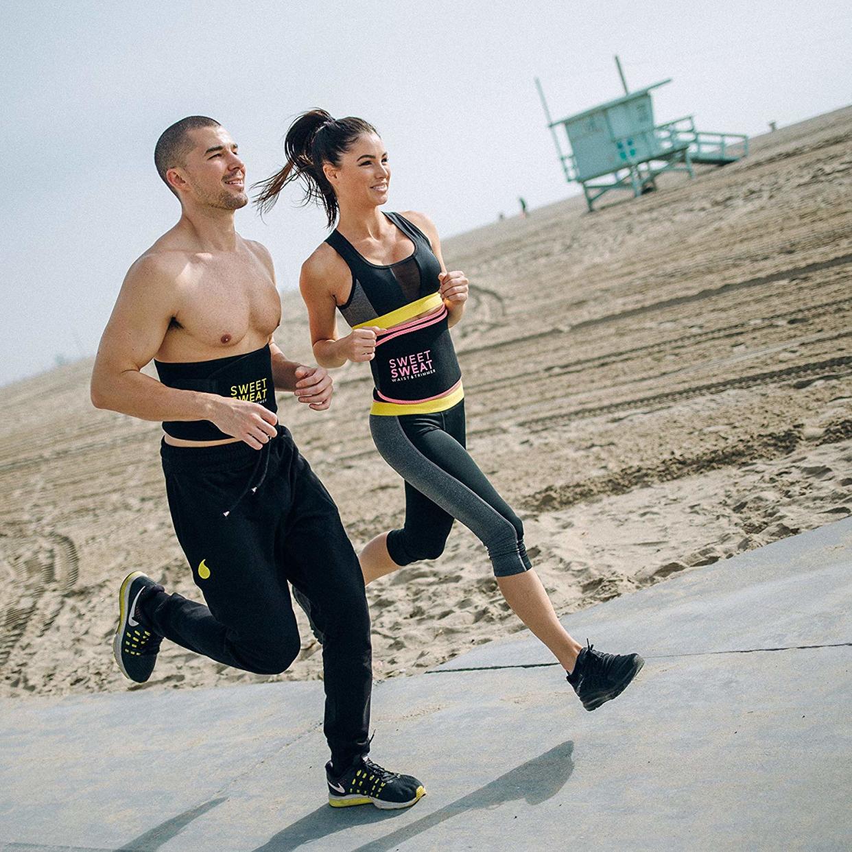 Two people jogging near beach while wearing waist trainer.