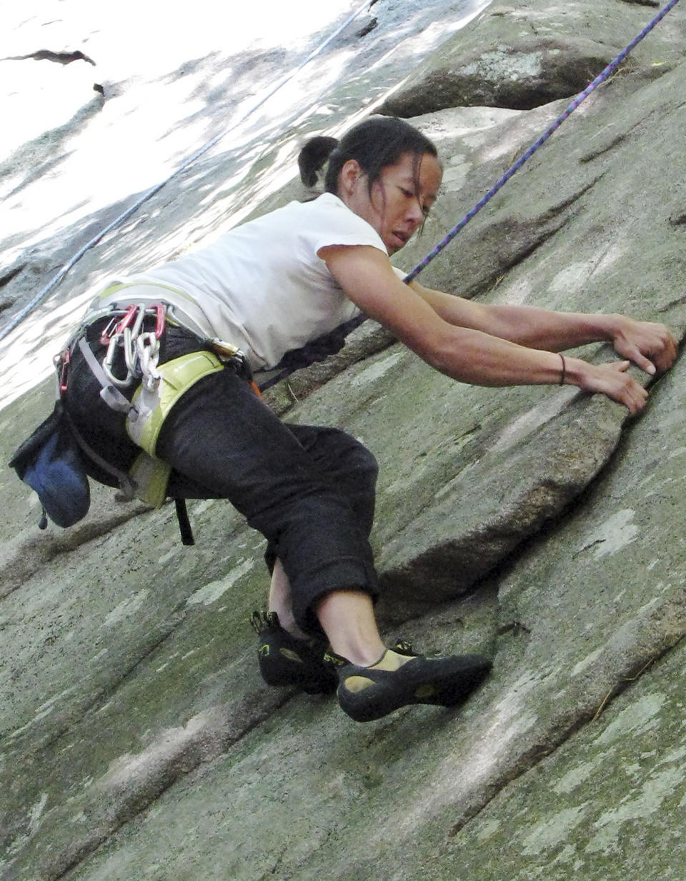 In this 2010 photo, Connie Yang, of York, Maine, climbs in Pawtuckaway State Park in Nottingham, N.H. Yang and Suzanne Turell made it safely down Longs Peak in Colorado Friday, Sept. 13, 2013, after being stranded by an ice storm for two days. The storm system that pummeled Colorado with rain caused an ice storm at higher elevations that pinned down the hikers in whiteout conditions about 800 feet below the summit. (AP Photo/Mary Schwalm)