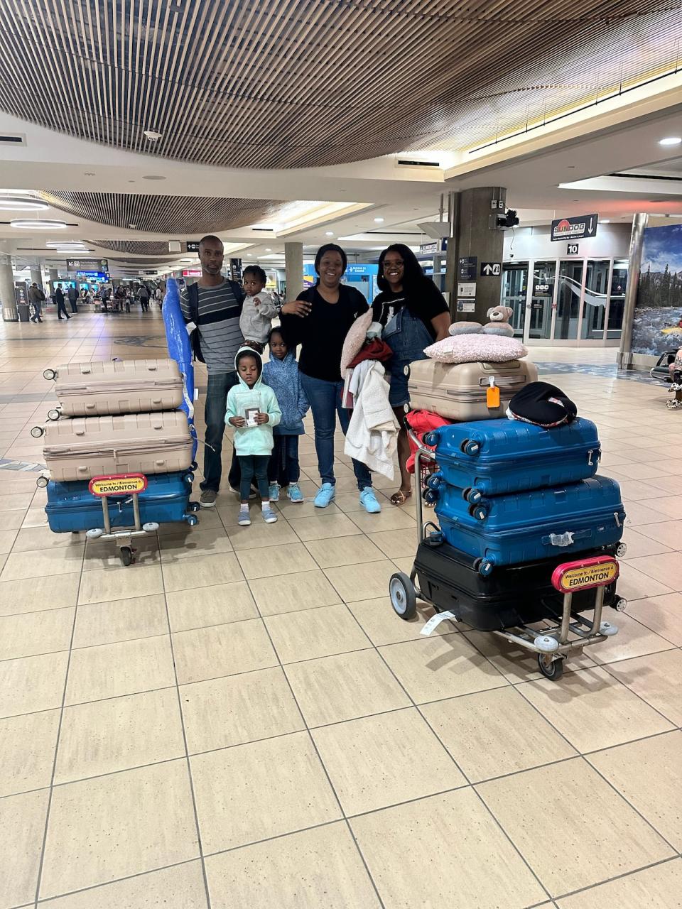 Williams, far right, meets a newly landed family at the YEG Edmonton International Airport earlier this year