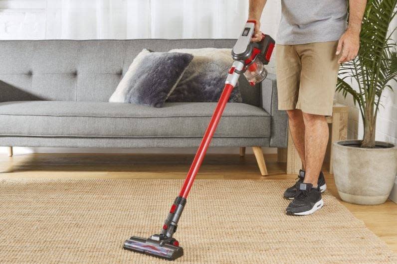 catalogue image shows man cut off from torso vacuuming with Aldi special buy vacuum