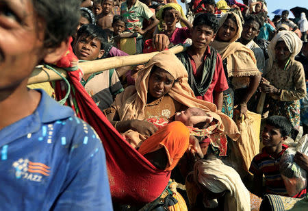 Fsarul Begum, a Rohingya refugee who fled from Myanmar is carried with her new born baby as they wait to be let through after crossing the border in Palang Khali, Bangladesh October 16, 2017. REUTERS/Zohra Bensemra