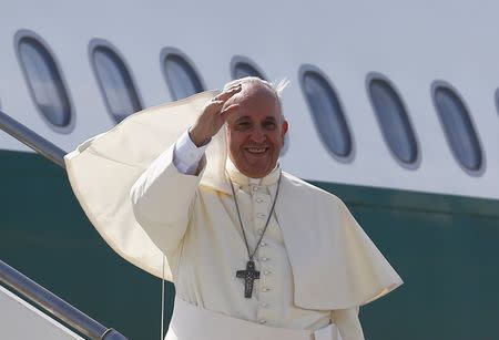 Pope Francis waves as he boards his plane to leave for his pastoral visit to South Korea, at the Fiumicino airport in Rome August 13, 2014. REUTERS/Alessandro Bianchi