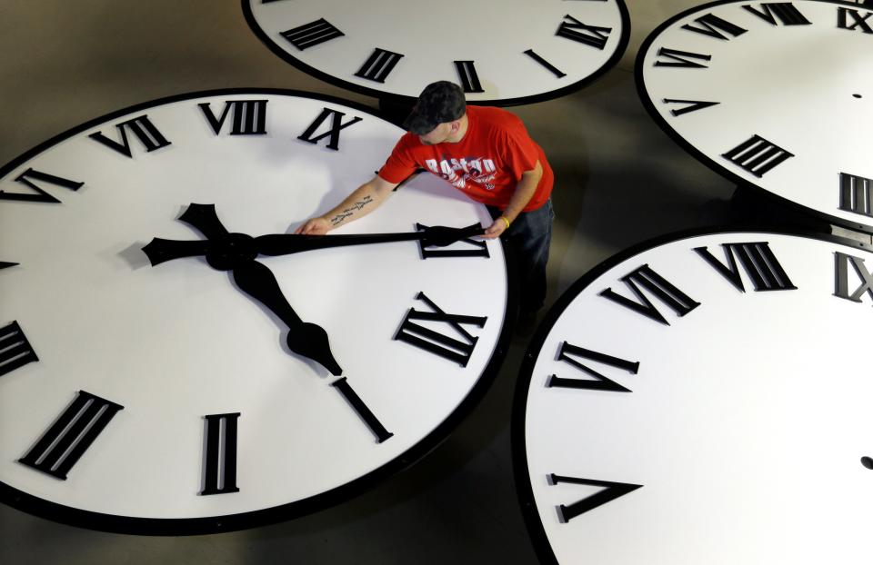 Dan LaMoore sizes hands for an 8-foot diameter silhouette clock at Electric Time Co., in Medfield, Massachusetts.