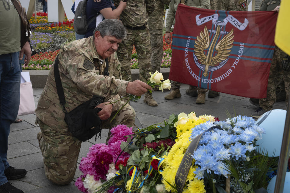 Veterans and people lay flowers to a spontaneous memorial to soldiers killed in war with Russia in the Independence square in Kyiv, Ukraine, Thursday, May 23, 2024. (AP Photo/Efrem Lukatsky)