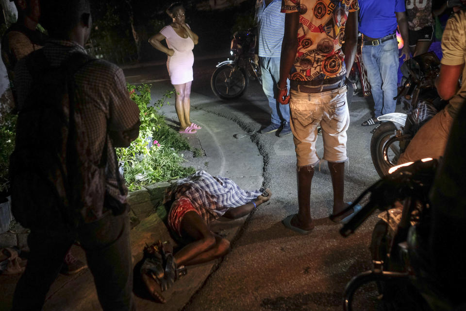 The body of a person lies on a street in the Petion-Ville neighborhood during a general strike in Port-au-Prince, Monday, Oct. 18, 2021. Workers angry about the nation's lack of security went on strike in protest two days after 17 members of a US-based missionary group were abducted by a violent gang. (AP Photo/Matias Delacroix)