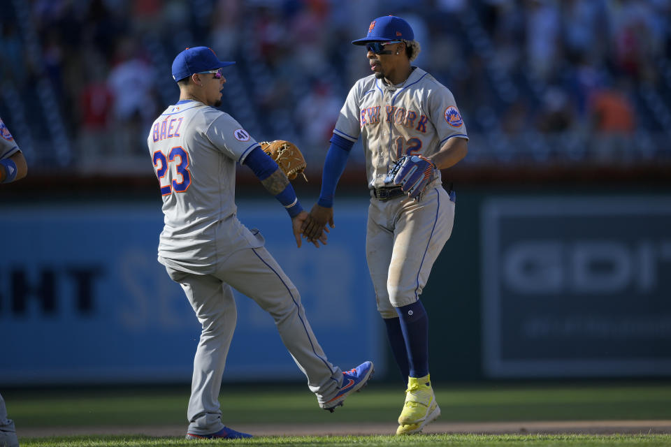 El boricua Francisco Lindor y su coterráneo Javier Báez, de los Mets de Nueva York, festejan la victoria sobre los Nacionales de Washington en el primer juego de una doble cartelera, el sábado 4 de septiembre de 2021 (AP Foto/Nick Wass)