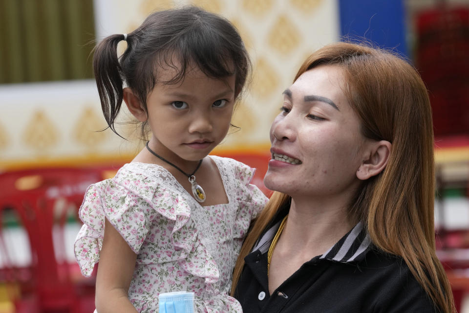 Paweenuch Supolwong, 3, the only child to emerge unscathed from the mass killing attack at the day care center, is held by her mother Anonpai Srithong, 35, during an interview inside Wat Si Uthai temple temple in Uthai Sawan, north eastern Thailand, Saturday, Oct. 8, 2022. A former police officer burst into a day care center in northeastern Thailand on Thursday, killing dozens of preschoolers and teachers before shooting more people as he fled. (AP Photo/Sakchai Lalit)