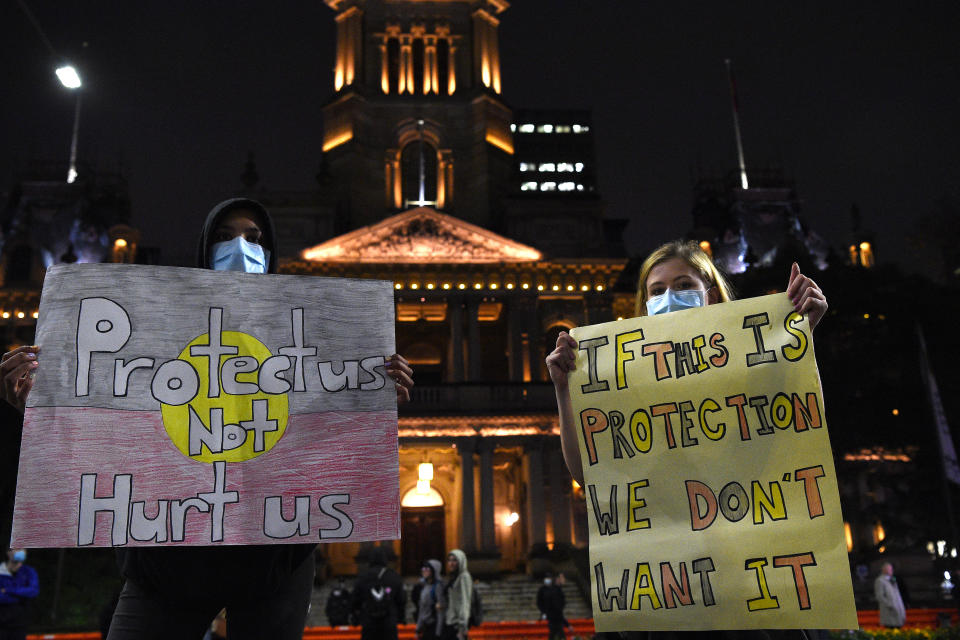 Protesters holding placards are seen during a Stop Black Deaths in Custody: Solidarity with Long Bay Prisoners vigil at Sydney Town Hall in Sydney on Friday. Source: AAP