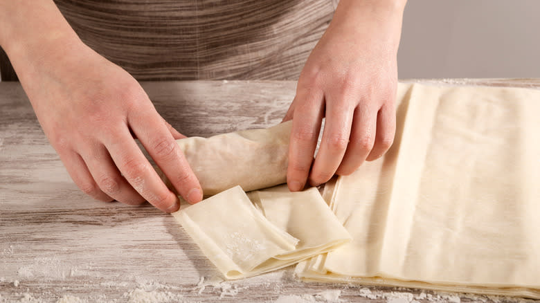 hands rolling a piece of phyllo pastry