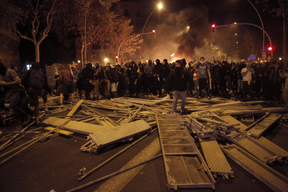 Protestors make barricades in the street during clashes with police in Barcelona, Spain, Wednesday, Oct. 16, 2019. Spain's government said Wednesday it would do whatever it takes to stamp out violence in Catalonia, where clashes between regional independence supporters and police have injured more than 200 people in two days. (AP Photo/Joan Mateu)